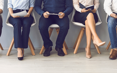 Four people sit in a row and prepare for their job interview 